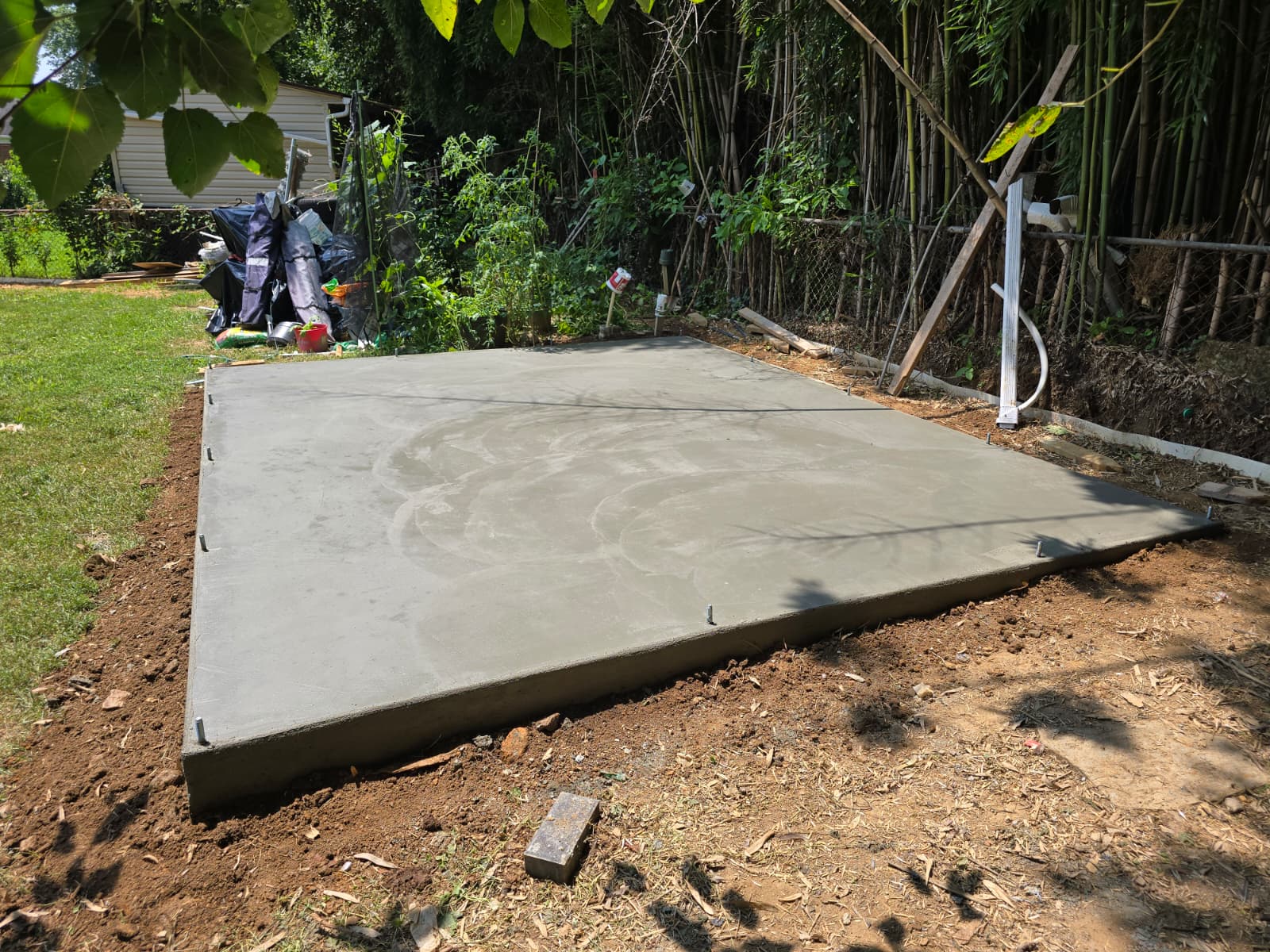 Freshly poured concrete shed foundation pad