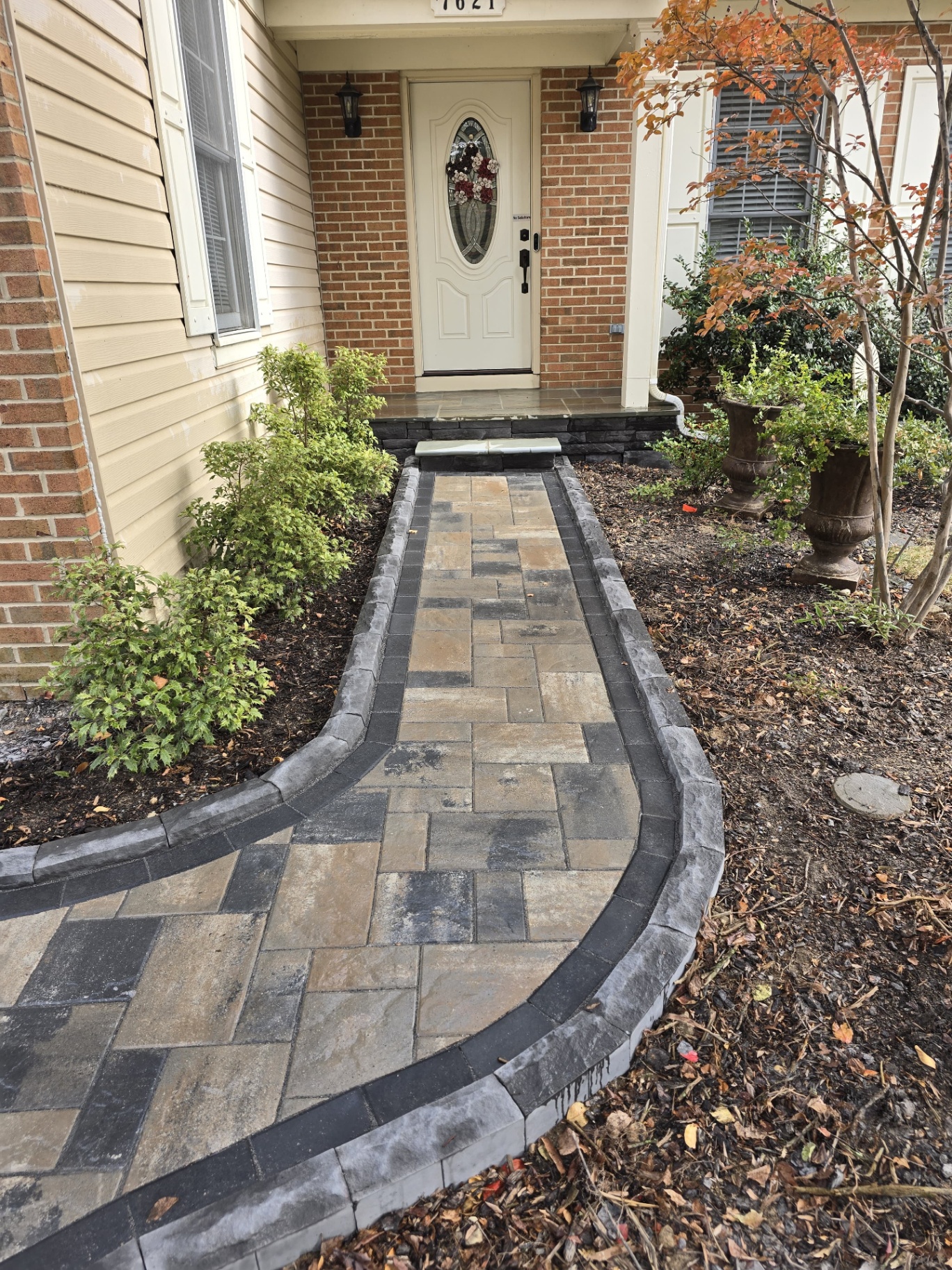 Curved front entry paver walkway with stone border