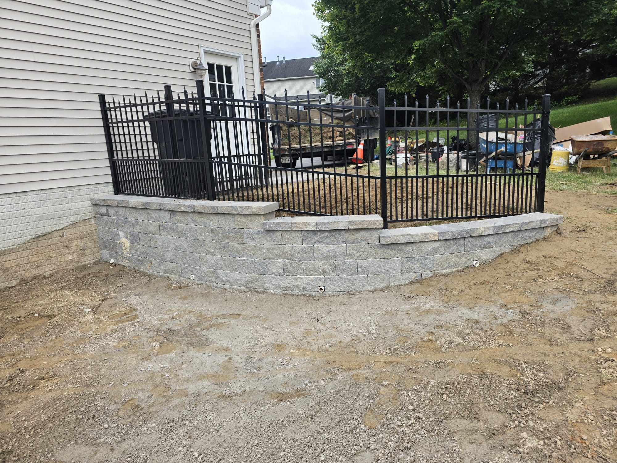Curved retaining wall with iron fence